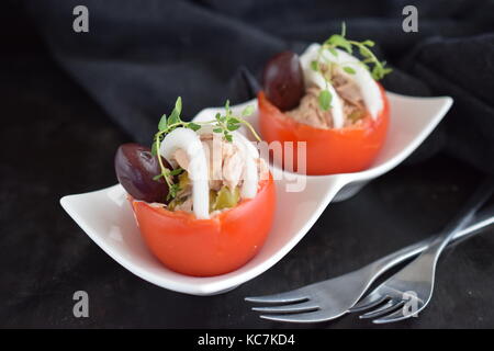 Tomato stuffed with tuna olives and onions. Healthy eating concept. Selective focus Stock Photo