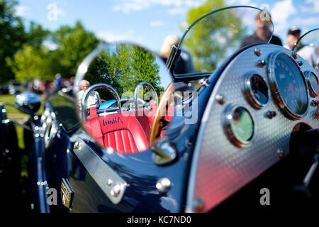 Reflection in side mirror of the steering wheel, and seats of Allard J2X MK II, modern version of the 1950s British competition roadster, London, Canada. Stock Photo