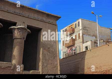 Temple of Khnum, reliefs on the wall and residential building in the town of Esna, Upper Egypt Stock Photo