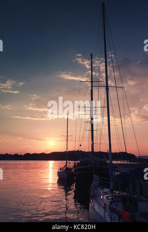 Vertical silhouette photo of sailing ship moored in port of old Nesebar at sunset, Bulgaria Stock Photo