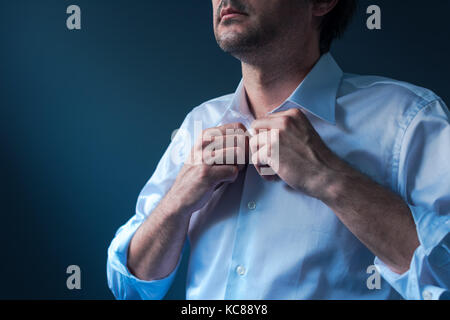 Businessman getting dressed for job interview, man buttoning white shirt Stock Photo