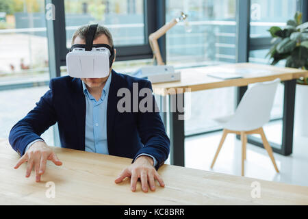 Pleasant handsome man putting his hands on the table Stock Photo