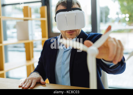 Nice confident man looking at the windmill model Stock Photo
