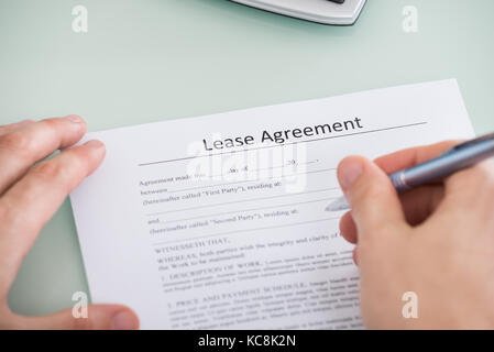 Close-up Of A Person Hand Over Lease Agreement Form Stock Photo