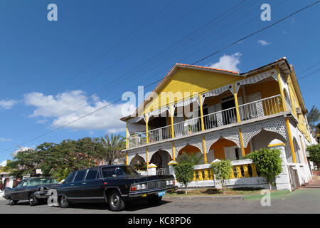 CIENFUEGOS, CUBA, FEBRUARY 17, 2014 : Classic old American car and colonial architecture. Classic cars are still in use in Cuba and old timers have be Stock Photo