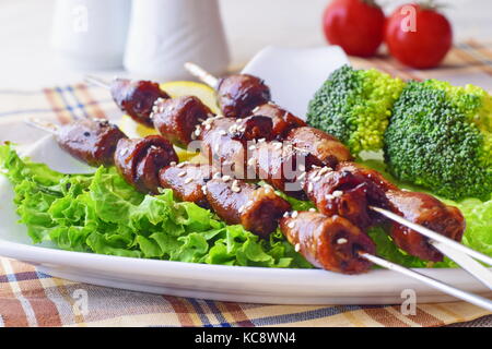 Oven cooked chicken hearts on skewers with vegetables. Healthy food Stock Photo