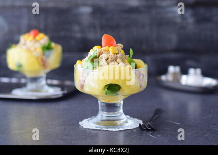 Salad with chicken fillet, pineapple, mushrooms, walnuts in a glass on a grey abstract background. Healthy eating concept. Russian traditional fo Stock Photo