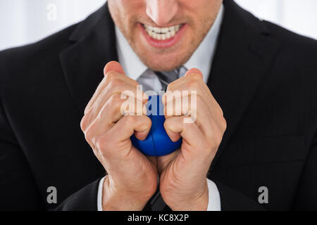 Close-up Of Businessman Pressing Stress Ball In Office Stock Photo