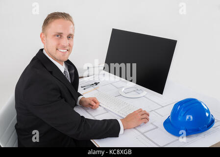 Young Happy Architect Working On Computer At Office Stock Photo