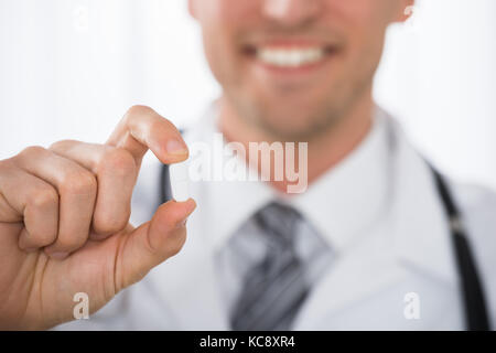 Close-up Of Happy Male Doctor Hand Holding Pill In Clinic Stock Photo