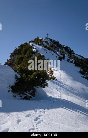 view of summit cross of snowy mountain Bruenstlkreuz in spring, Garmisch-Partenkirchen, Bavaria, Germany Stock Photo