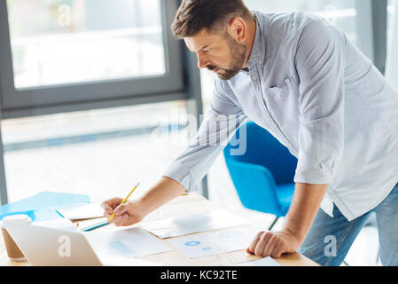 Serious bearded male making notes Stock Photo
