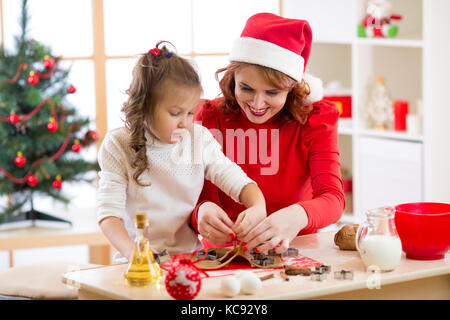 Mother and child daughter baking cakes to christmas eve Stock Photo