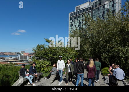Pedestrians walk along the High Line in New York, New York on October 01, 2017. Stock Photo