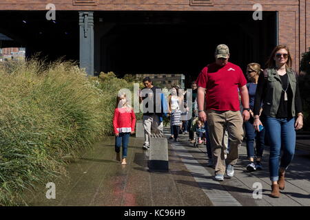 Pedestrians walk along the High Line in New York, New York on October 01, 2017. Stock Photo