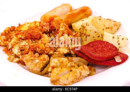 Omelet with vegetables, potatoes with sausage on the white plate Stock Photo