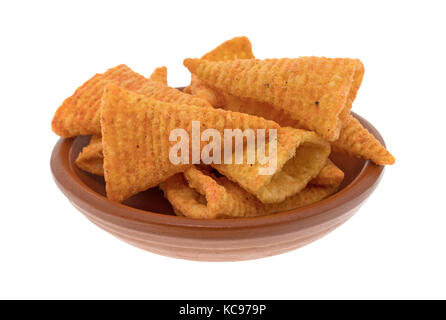 A small red clay bowl filled with cheese flavored cone shaped corn chips isolated on a white background. Stock Photo
