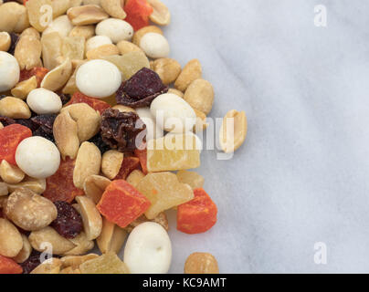 Close view of yogurt covered raisin, fruit and nut trail mix on a gray marble counter top. Stock Photo