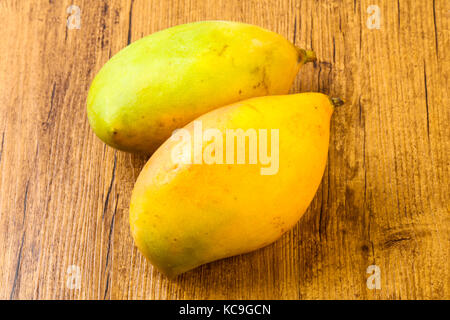 Sweet mango fruit over the wooden background Stock Photo