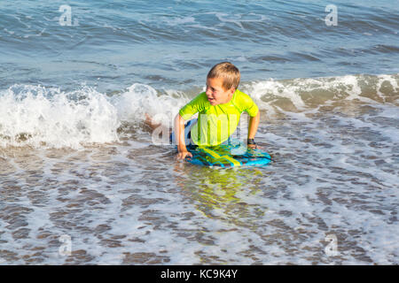 Avon, Outer Banks, North Carolina, USA.  Young Boy with his Boogie Board Landing on the Beach. Stock Photo