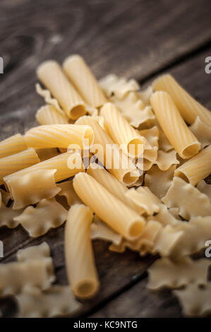Mixed dried pasta selection on wooden background. Close up Stock Photo