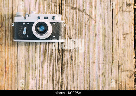 35mm Vintage Old Retro Small-Format Rangefinder Camera On Old Wooden Boards Desk Surface. Stock Photo