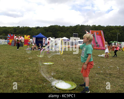 Boy blowing bubbles at a music festival. Stock Photo