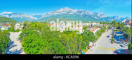 KEMER, TURKEY - MAY 12, 2017: The wide panorama of scenic resort with lush green public garden, huge rocky mountains and numerous tourist hotels, on M Stock Photo
