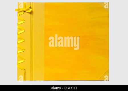 Yellow hand crafted book with STAB binding bound with bookcloth and hand decorated paper, sewn with ribbon isolated on white background Stock Photo