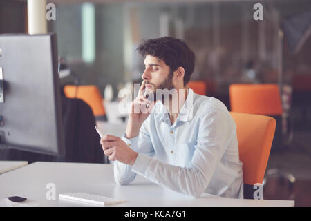young business man working on desktop computer at his desk in modern bright startup office interior Stock Photo