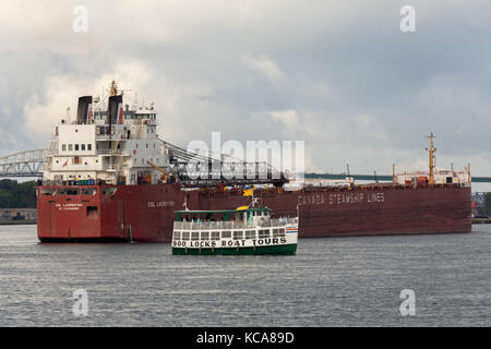 Sault Ste Marie, Michigan - Tourists on a boat tour of the Soo Locks watch the CSL Laurentien, a bulk cargo freighter waiting to enter the locks. The  Stock Photo