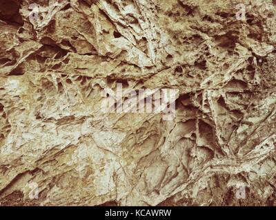 Sandstone texture detail,  nature errosion. Closeup rock erosion holes sea wall. Texture background. Stock Photo