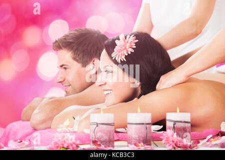 Close-up Of A Young Smiling Couple Receiving Shoulder Massage At Beauty Spa Stock Photo