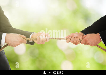 Close-up Of A Two Businessman Pulling Rope In Opposite Direction Stock Photo