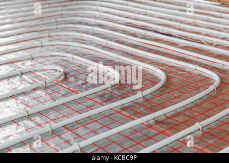 Underfloor heating installation. Close up on water floor heating system interior. plumbing pipes. Individual Heating. Stock Photo