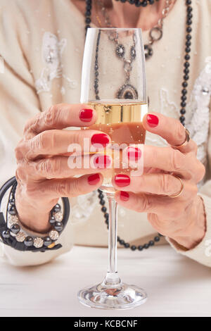 Female hands holding glass of champagne. Stock Photo