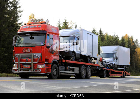 TAMMELA, FINLAND - SEPTEMBER 29, 2017: Red Renault Premium 450 truck of Rahti-Kaleva Oy transports two Iveco Daily light trucks along highway. Stock Photo
