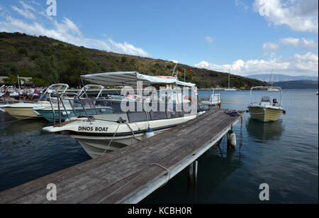 Yachts and pleasure motor boats tied to a jetty or pier moorings at Agni on the greek island of Corfu. Leisure craft for hire berthed in a greek port. Stock Photo