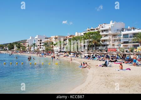 People on the sandy beach at Puerto Pollensa on the Spanish island of Majorca on September 5, 2017. Stock Photo