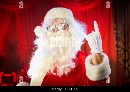 Santa Claus shows a hand a heavy rock symbol. Stock Photo