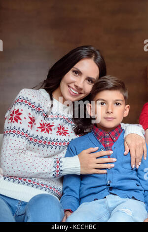 mother and son celebrate the new year at a Christmas tree with gifts