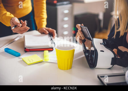 Two business woman working together at the office and testing virtual reality glasses Stock Photo