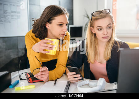 Two business woman working together at the office and using laptop Stock Photo