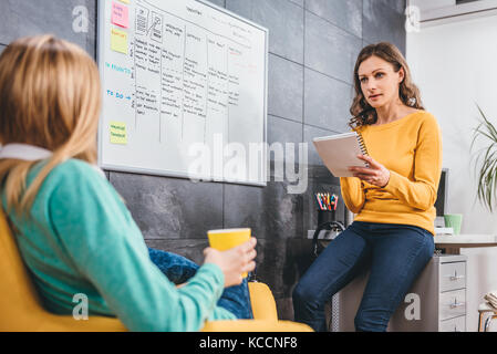 Two business woman having meeting in front of the whiteboard Stock Photo