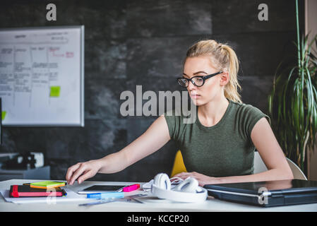Young business woman wearing eyeglasses working in the office Stock Photo