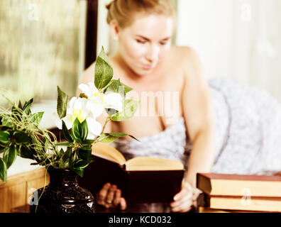 young woman reads a book lying on a desk in front of a window. old style, lolita concept Stock Photo