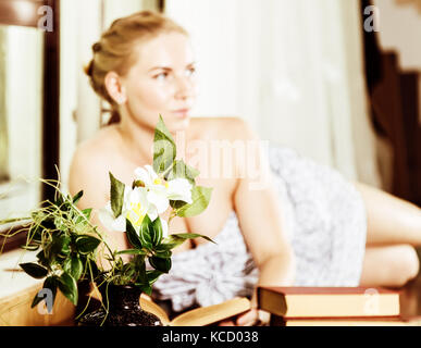 young woman reads a book lying on a desk in front of a window. old style, lolita concept Stock Photo