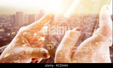 digital tablet double exposure and and cityscape background. Business technology concept. Stock Photo