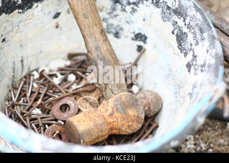 old hammer and neils in cement bucket Stock Photo
