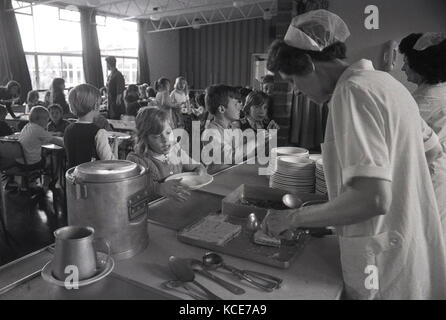 1970s, historical, school dinner ladies serving food to children at lunchtime, Langbourne Primary School, Dulwich, London, SE21, England, UK. Stock Photo
